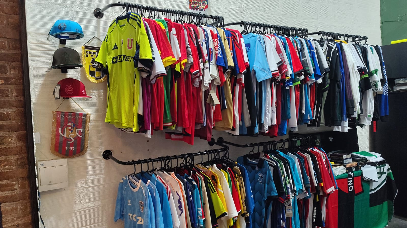 Varal com dezenas de camisas de futebol originais na loja Garrincha Shirts