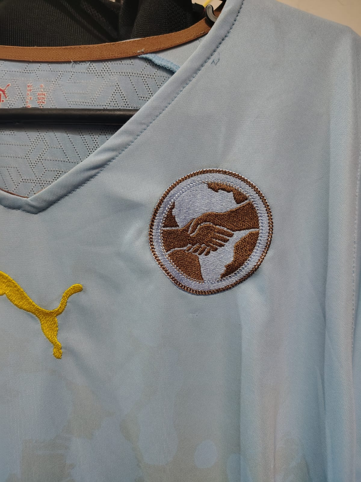 Camisa Puma Africa Unity 2010 – escudo do aperto de mãos