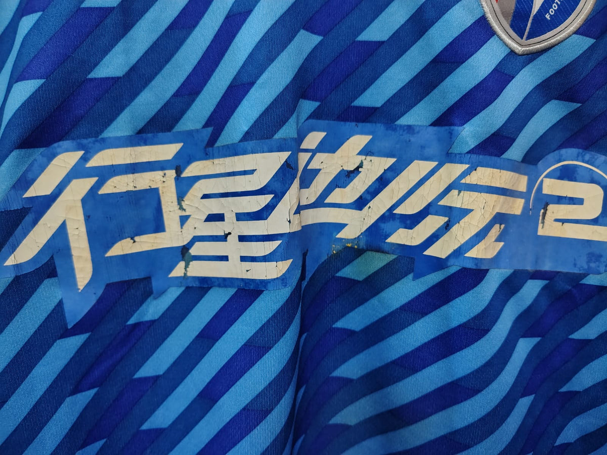 Camisa Shanghai Shenhua 2012 – detalhe do patrocínio craquelado