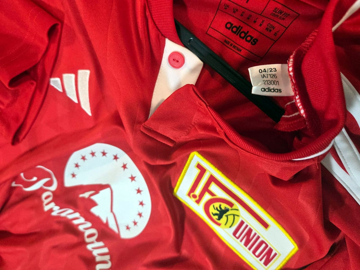 Camisa Union Berlin Home 2023/24 – escudo e etiqueta adidas
